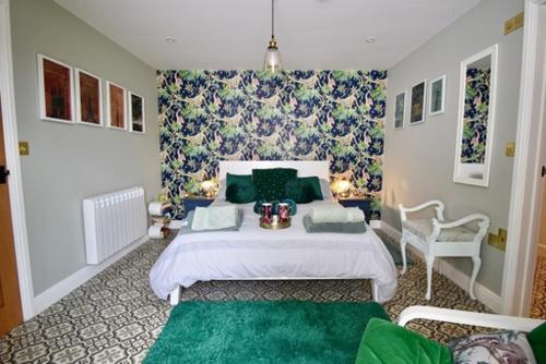 een slaapkamer met een groot bed met groene kussens bij Sheepwash Farm Rural Spa Retreat Cottages in Ticehurst