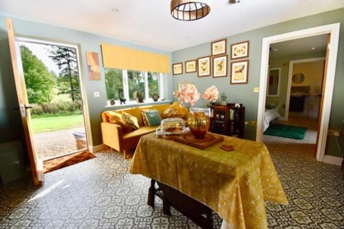een woonkamer met een tafel en een bank bij Sheepwash Farm Rural Spa Retreat Cottages in Ticehurst