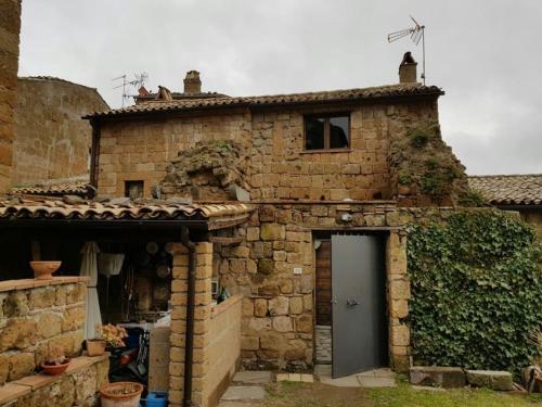 an old stone house with a door in front of it at il sogno di Civita in Civita di Bagnoregio