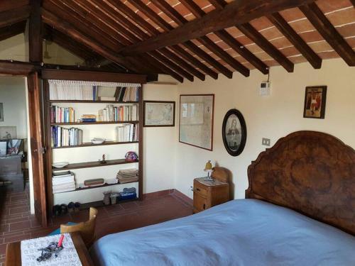 a bedroom with a bed and a book shelf with books at il sogno di Civita in Bagnoregio