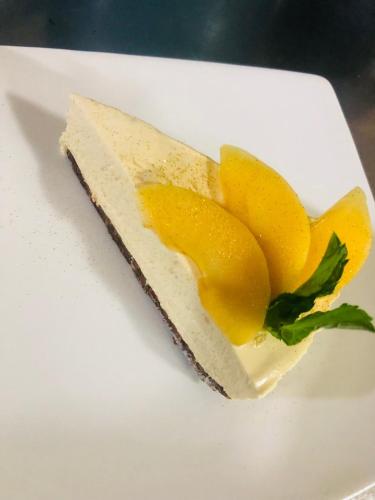 a piece of cheesecake with a flower on a white plate at Getahovit Resort in Ijevan