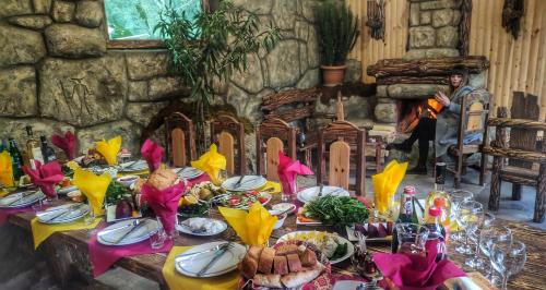 a table with food and a man standing in front of a fireplace at Getahovit Resort in Ijevan