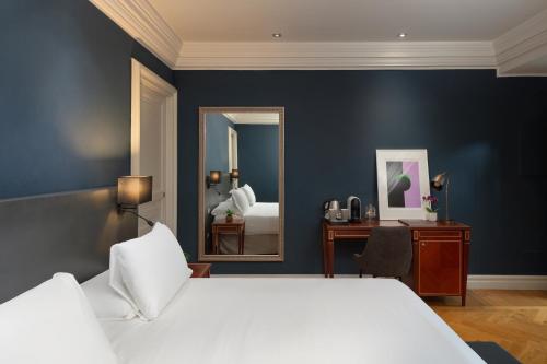 a bedroom with a large bed and a mirror at Hotel Principe Torlonia in Rome