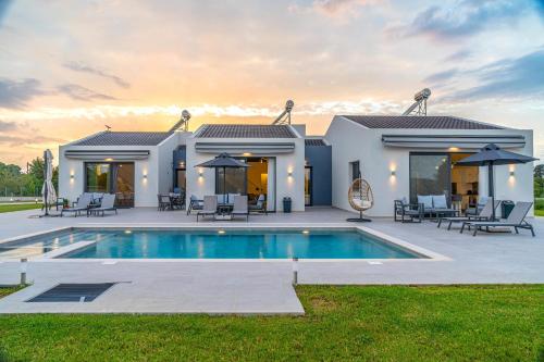 a house with a swimming pool in front of it at Vathy Villas in Preveza