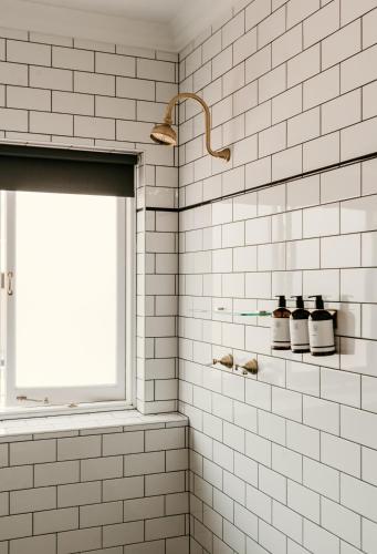 a bathroom with white subway tiles and a window at The Imperial Hotel in Murwillumbah