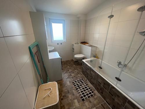 a bathroom with a toilet and a tub and a sink at Top 2-Zimmerwohnung mit Balkon in Ludwigsfelde