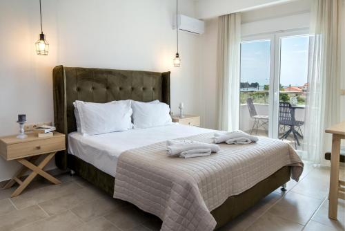a bedroom with a large bed with towels on it at Agali Rooms in Skala Rachoniou