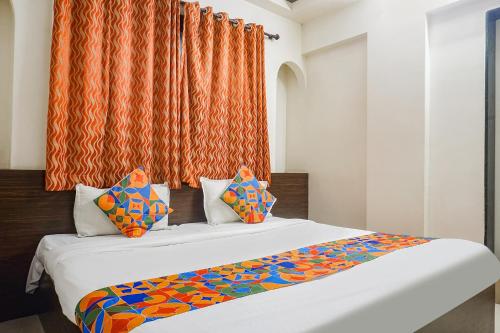 Duas camas num quarto com uma cortina laranja em FabHotel Royal Samrat em Pune