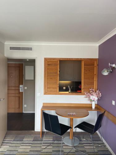 - un salon avec une table et un mur violet dans l'établissement Dream Dwell Paris - Paris Expo Porte Versailles beautiful apartment with balcony, à Issy-les-Moulineaux