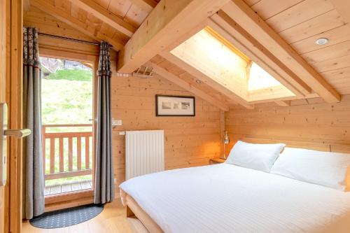 1 dormitorio con 1 cama en una habitación con ventana en ORTA Chalet en Les Gets