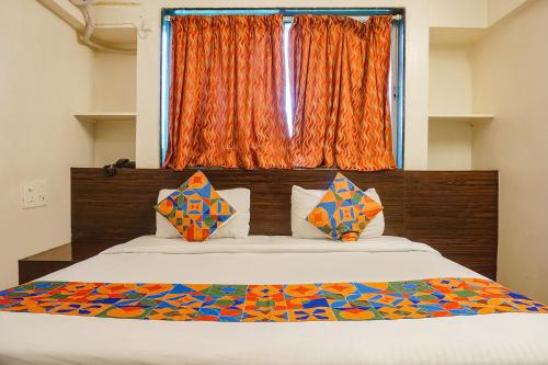 a bedroom with a large bed with an orange window at FabExpress Royal Samrat - Ram Manohar Lohiya in Pune