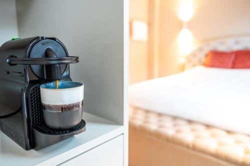 a coffee maker on a counter next to a bedroom at Renovated Parkside Gem - 2 person studio in the Pijp in Amsterdam