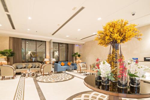 a hotel lobby with a large vase of flowers on a table at Jiwar Almasi Hotel in Jeddah