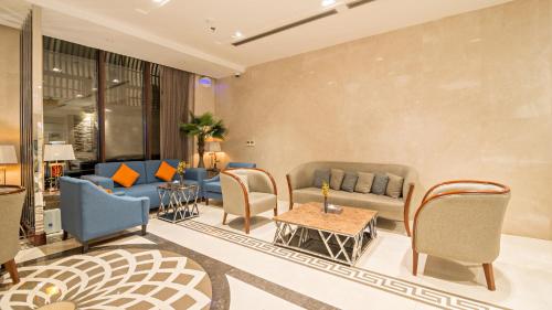 a lobby with couches and chairs and a table at Jiwar Almasi Hotel in Jeddah