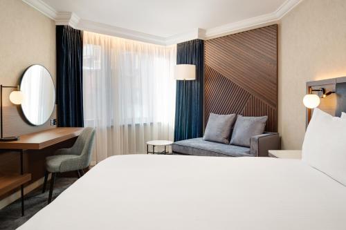 a hotel room with a bed and a desk at Hilton London Metropole in London