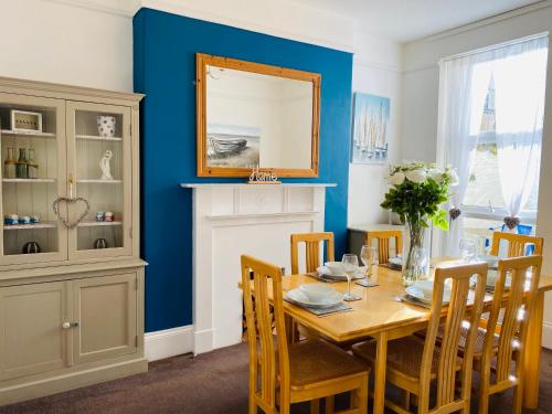 a dining room with a table and a mirror at Ocean Terrace, Ilfracombe, 4 bedrooms, Sleeps 8, Stunning Sea Views, Parking, Garden, Pet Friendly in Ilfracombe