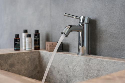 a sink with a stream of water from a faucet at Mare Blue Suites in Georgioupolis