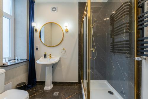La salle de bains est pourvue d'un lavabo et d'une douche. dans l'établissement KaJo Apartamenty, à Świdwin