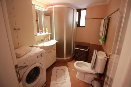 a bathroom with a washing machine and a toilet at Elida Apartments in Gjirokastër