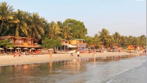 uma praia com palmeiras e pessoas na praia em Blue Mirage Palolem Goa em Canacona