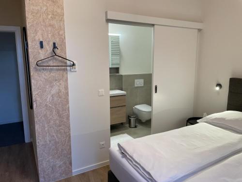a bedroom with a bed and a bathroom with a shower at Haus Karlich in Trausdorf an der Wulka