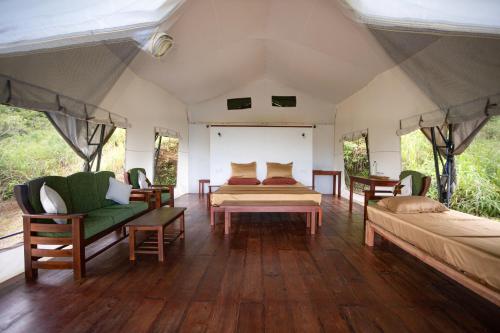 a bedroom with two beds and chairs in a tent at Bellway Chalets in Dedugala