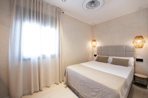 a bedroom with a bed and a window with a clock at MarPlana in Castelldefels