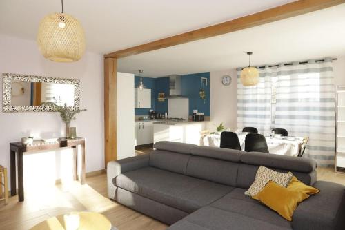 uma sala de estar com um sofá e uma sala de jantar em Maison Le Chapitre by La Boîte En Plus em Senlis