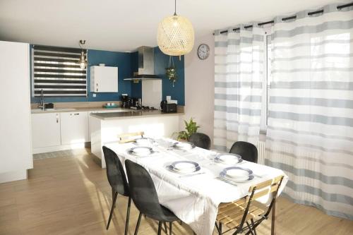 uma sala de jantar com uma mesa branca e cadeiras em Maison Le Chapitre by La Boîte En Plus em Senlis