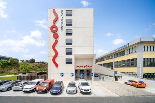a parking lot with cars parked in front of a building at Moov Hotel Lisboa Oriente in Lisbon