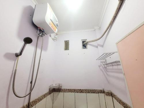 - une douche dans une chambre aux murs blancs avec une ouverture dans l'établissement Wisma Gahalta by Fans, à Karawang