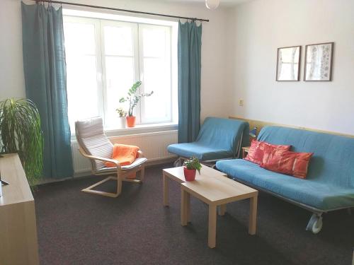 uma sala de estar com um sofá azul e uma cadeira em Apartmány Krkoškova em Brno