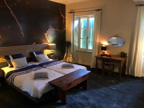 um quarto com uma cama grande, uma mesa e uma secretária em La Cerisaie - Chambres d'hôtes & gites em Riols