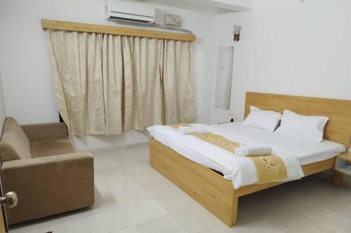 a bedroom with a bed and a chair and a television at Lonavala Villa in Lonavala