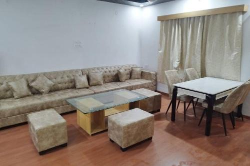 a living room with a couch and a table and chairs at Lonavala Villa in Lonavala