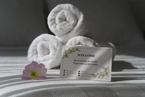 een handdoekendispenser en een bloem op een bed bij KAYA APARTMENTS in Kalkan