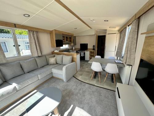 uma sala de estar com um sofá e uma mesa em The Ghillie's Van - Beautiful, luxury static caravan em Aberlour
