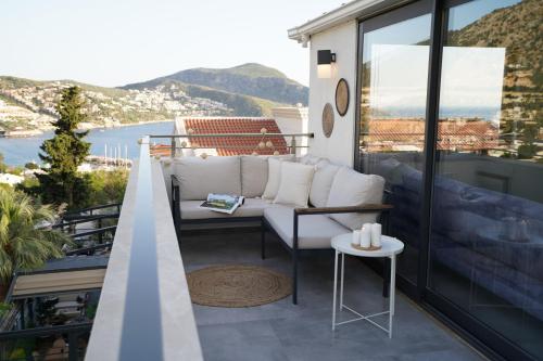 a balcony with a white couch and a table at KAYA APARTMENTS in Kalkan