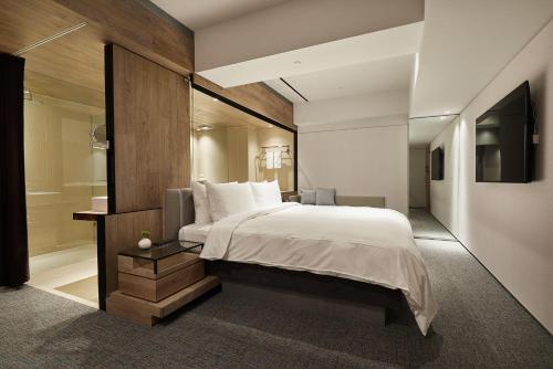 a bedroom with a large bed and a television at K Hotel Taipei Nanjing in Taipei
