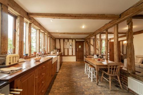 a kitchen with wooden beams and a table and chairs at Manor Farm Barn in Eye