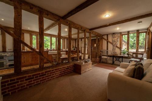 a living room with a couch and some windows at Manor Farm Barn in Eye