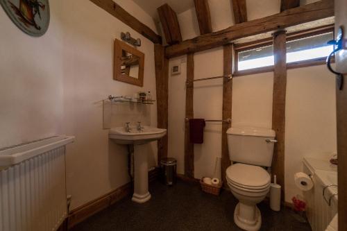 a bathroom with a toilet and a sink at Manor Farm Barn in Eye