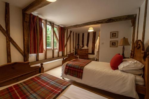 a bedroom with two beds and a window at Manor Farm Barn in Eye