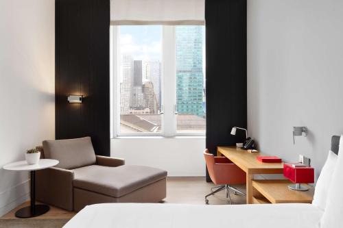 1 dormitorio con silla, escritorio y ventana en Andaz 5th Avenue-a concept by Hyatt en Nueva York