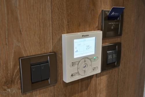 a hotel room with a safe and a monitor on a wall at K Hotel Taipei Nanjing in Taipei
