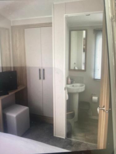 a bathroom with a sink and a toilet and a mirror at Montrose 25 in Turnberry