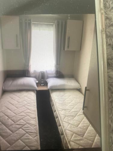 two beds in a small room with a window at Montrose 25 in Turnberry