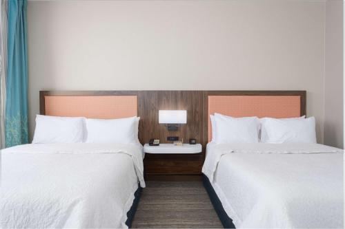 a hotel room with two beds and a table with a lamp at Hampton Inn & Suites - Orange Beach in Orange Beach