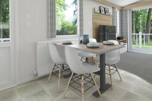 a dining room with a table and white chairs at The Cooper's Van - Beautiful, luxury static caravan in Aberlour