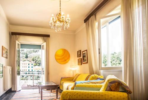 een woonkamer met 2 bedden en een kroonluchter bij San Rocco Flexyrent - Parking - WiFi - Aircon in Rapallo
